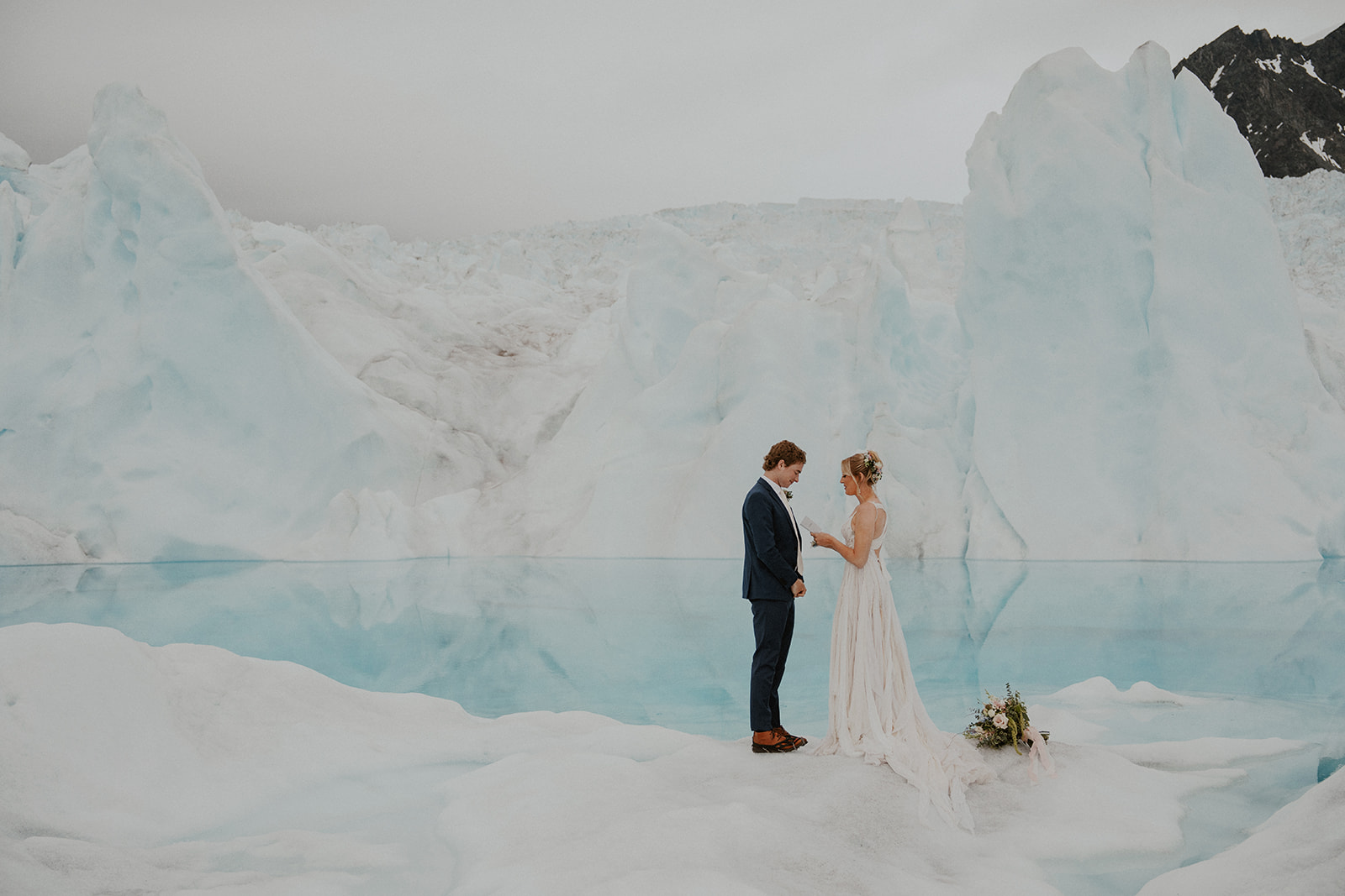 Bride and groom exchanging vows during their Alaska helicopter elopement at Knik Glacier