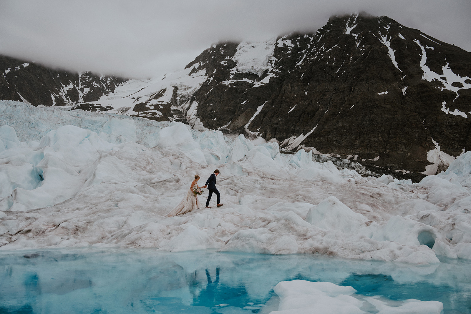 Bride and groom walking at Knik Glacier during their Alaska helicopter elopement