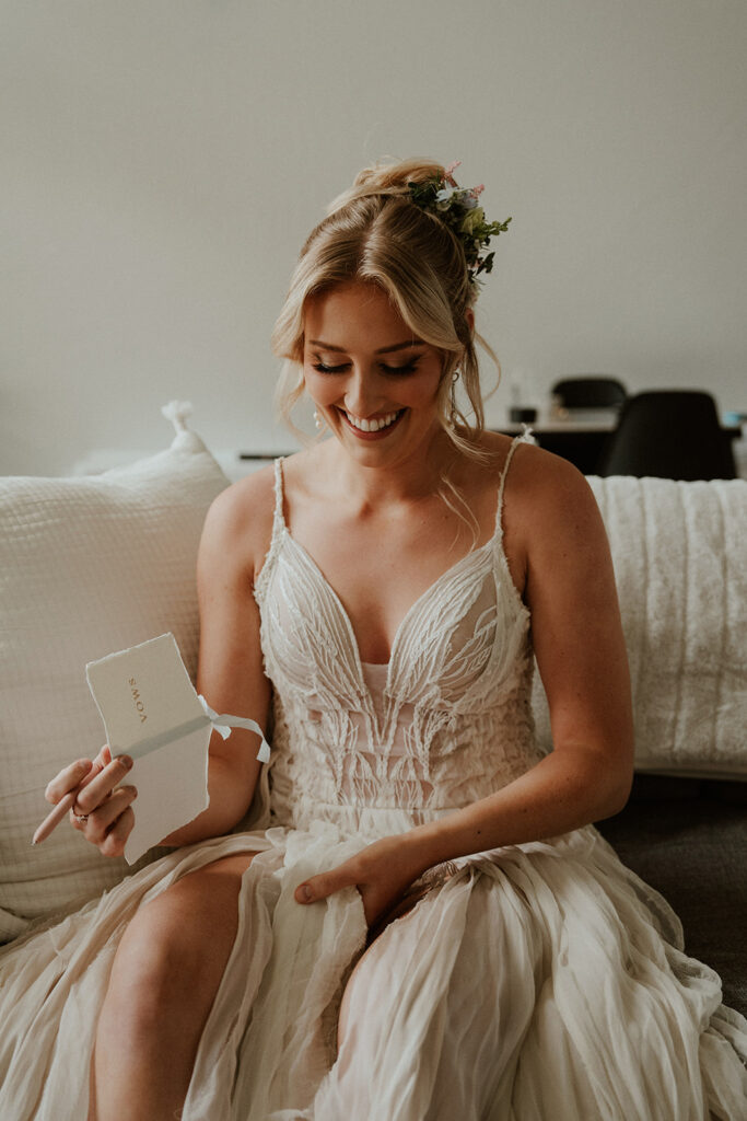 Bride writing in her white vow book before her intimate elopement in Alaska