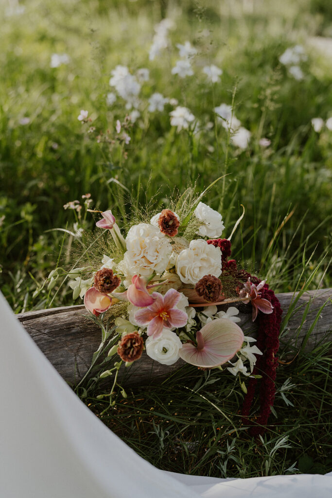 Bride florals laying on a fallen tree stump by Lady Sunshine Florals