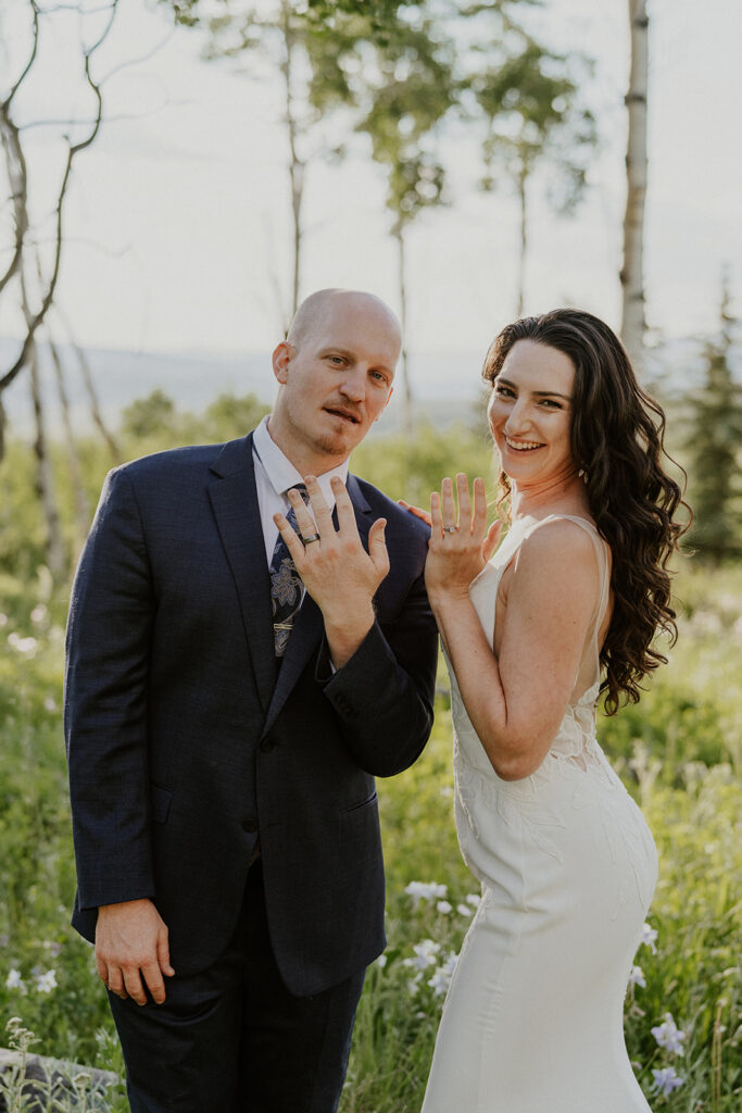 Bride and groom showing off their weddings rings after exchanging vows in the Colorado mountains