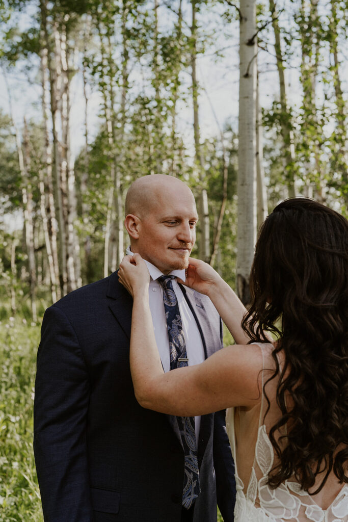 Bride adjusting the grooms suit