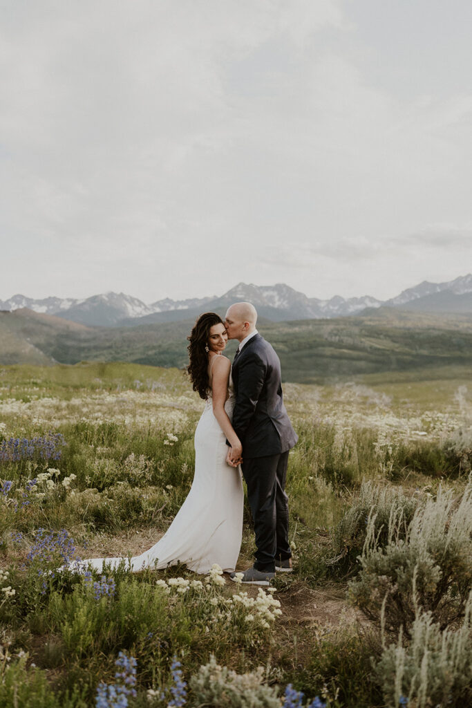 Groom kissing his bride during their intimate Colorado elopement in the Breckenridge mountains