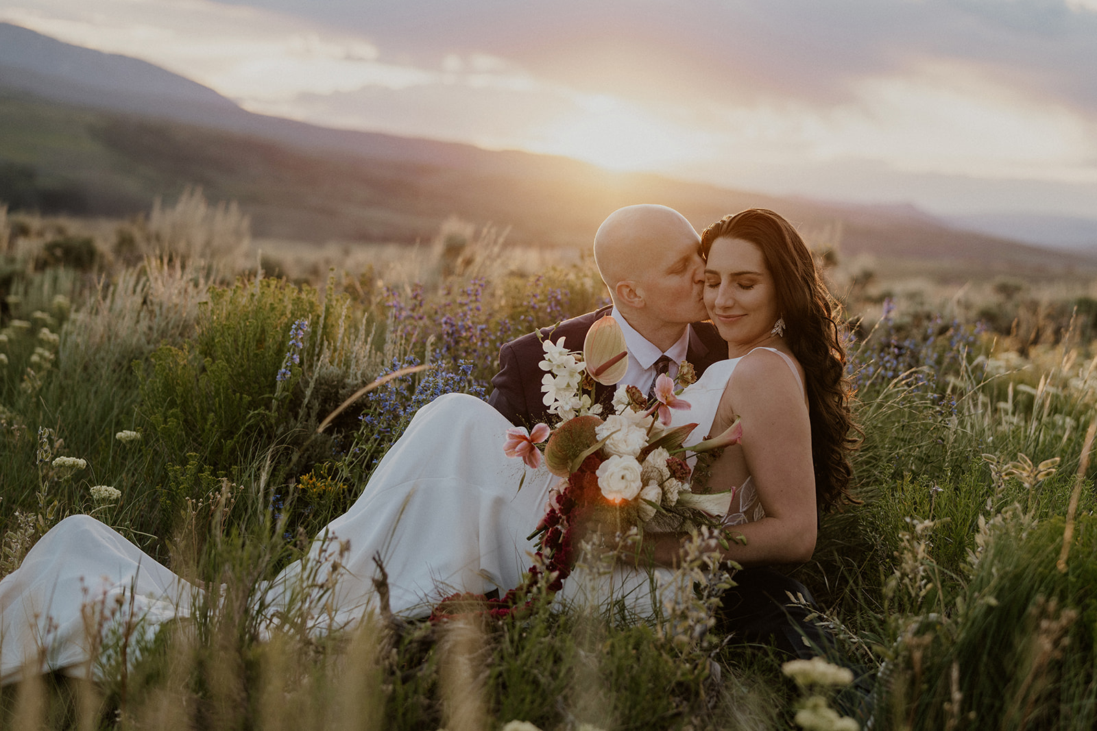 Golden hour elopement photos of a couple sitting in the alpine meadows in Breckenridge, Colorado