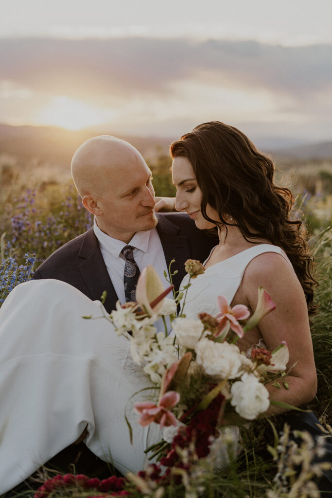 Golden hour elopement photos of a couple sitting in the alpine meadows in Breckenridge, Colorado