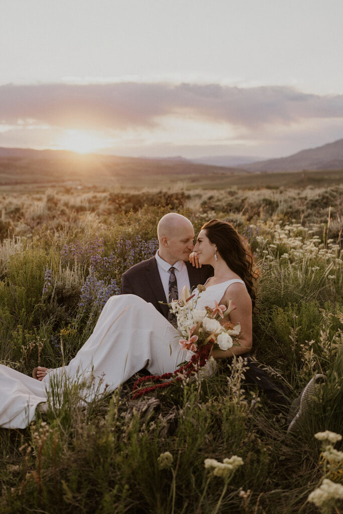 Golden hour elopement photos of a couple sitting in the alpine meadows in Breckenridge, Colorado