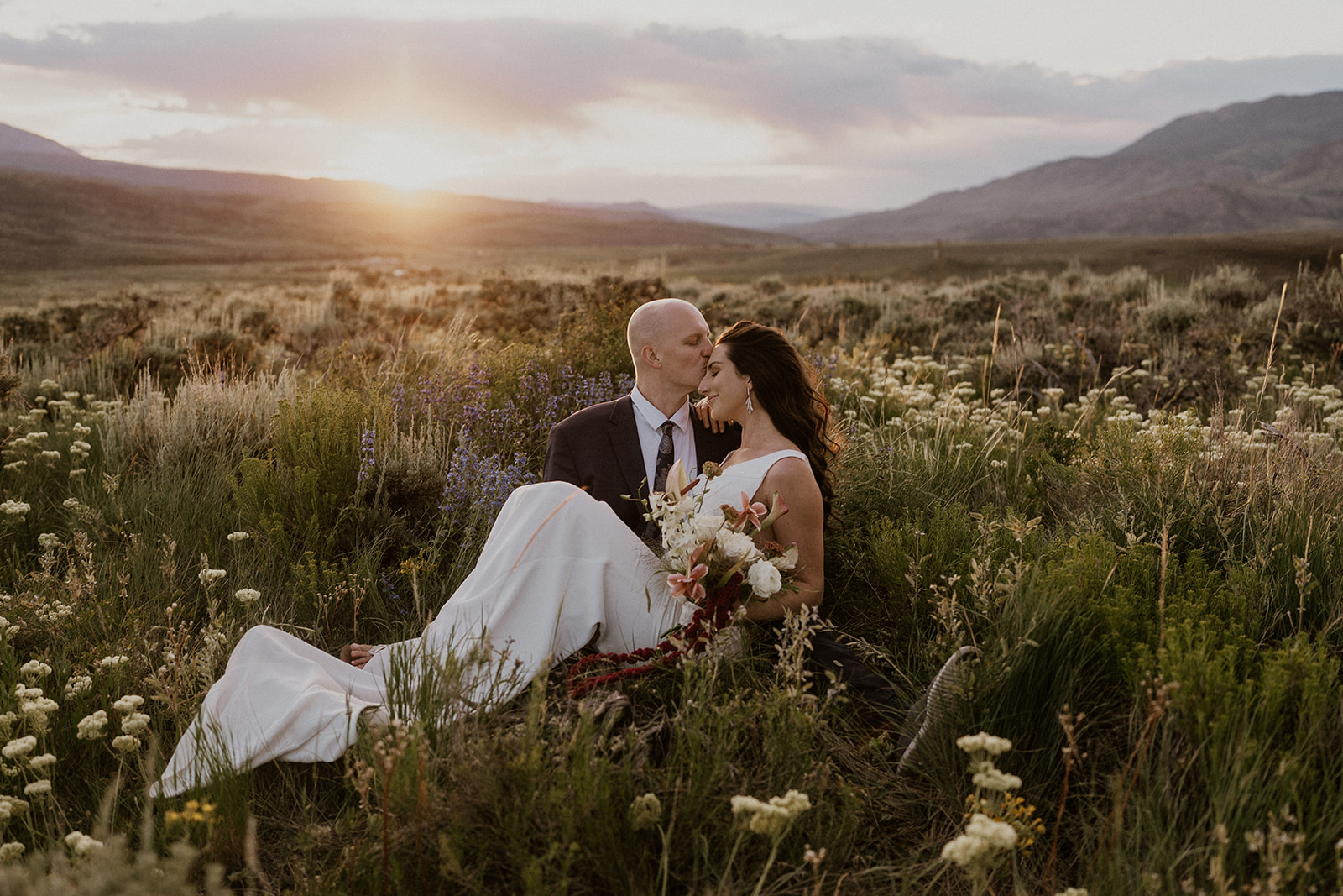 Golden hour elopement photos of a couple sitting in the alpine meadows in Breckenridge, Colorado