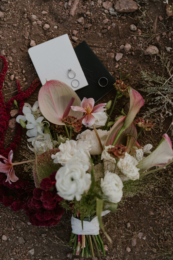 Colorado mountain elopement details with florals by Lady Sunshine florals, vow books, and rings.