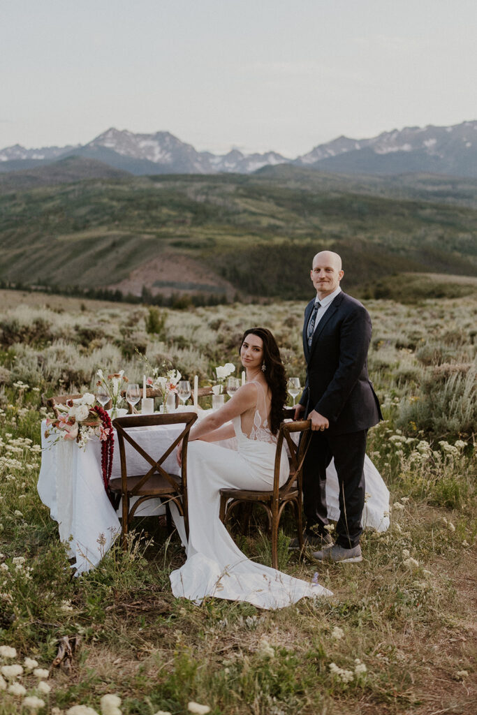 Bride and groom seated at their sweetheart table in the mountains during their Breckenridge Colorado elopement.