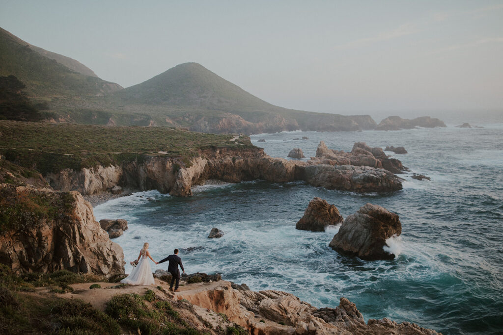 Bride and groom walking along the cliffs for their Big Sur elopement photos