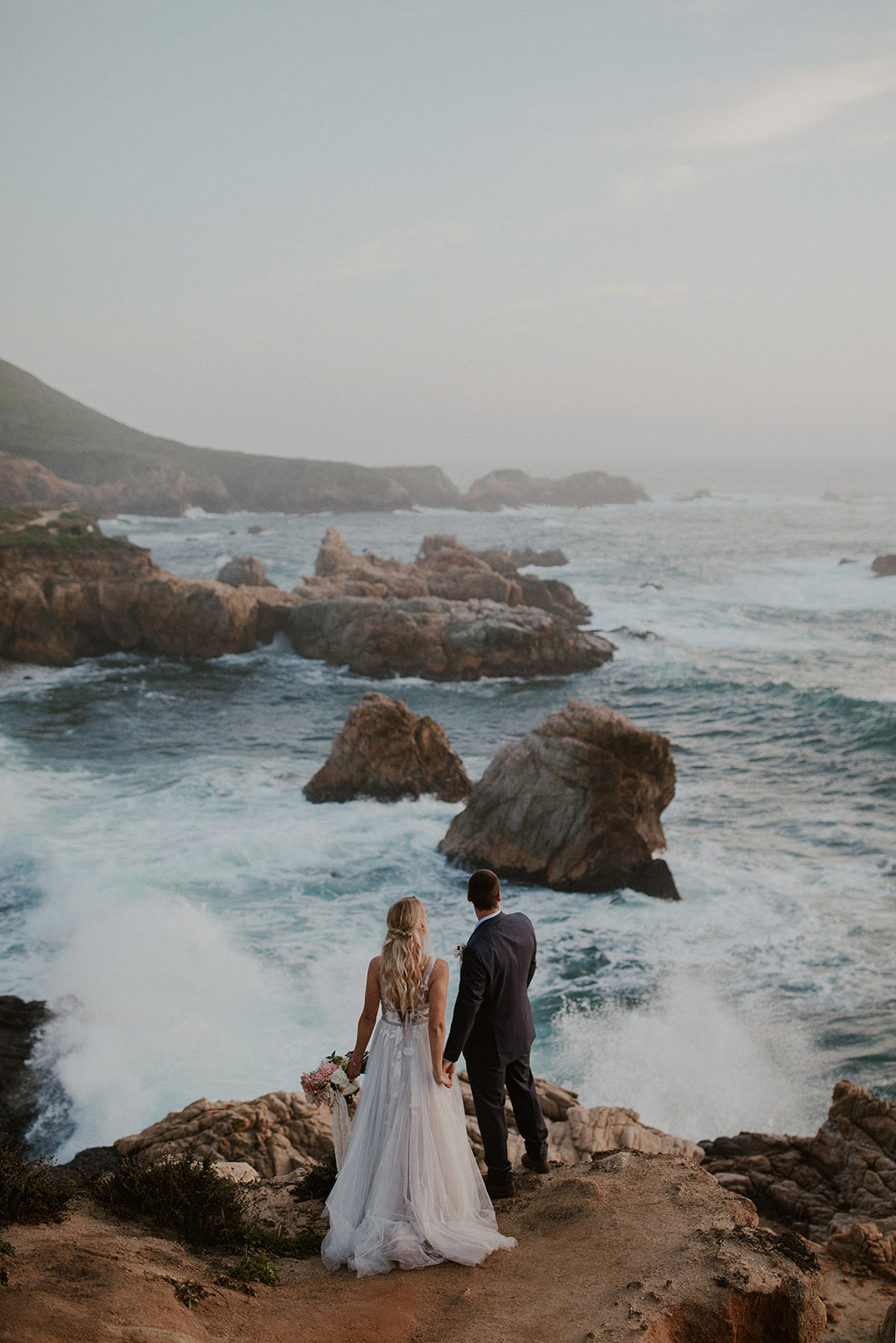 Bride and groom watching the waves crash during their Big Sur elopement