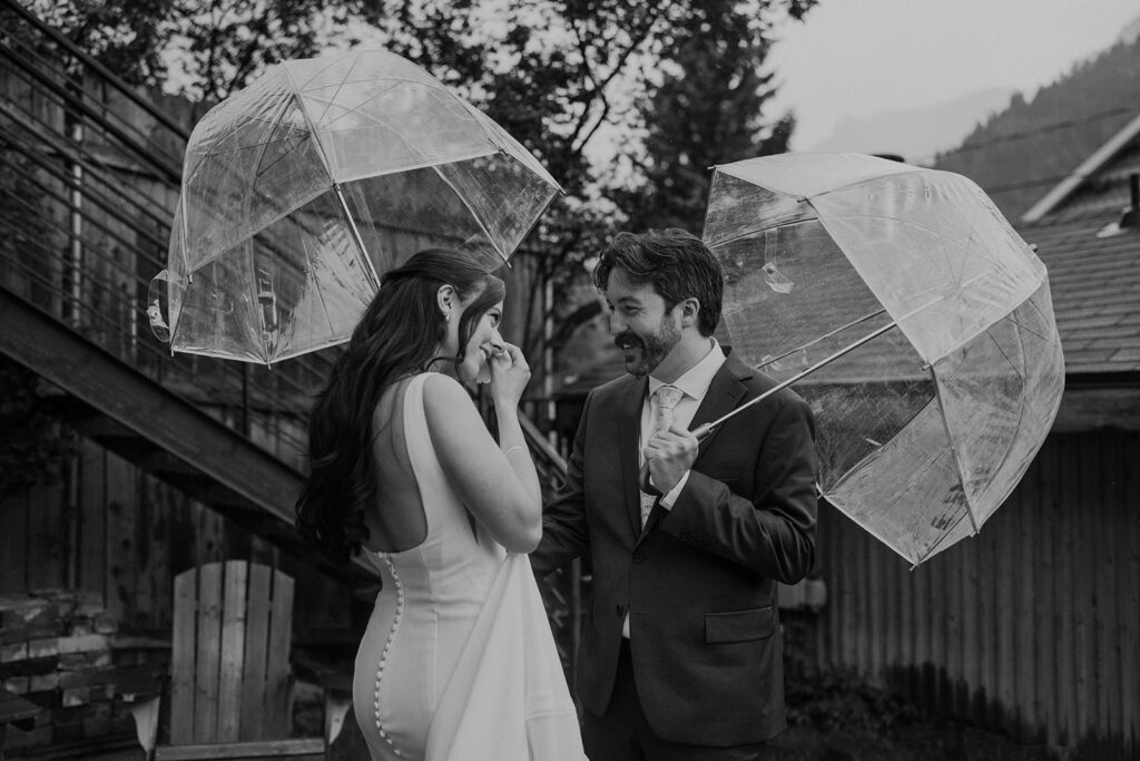 Bride and groom first look in the rain with clear umbrellas
