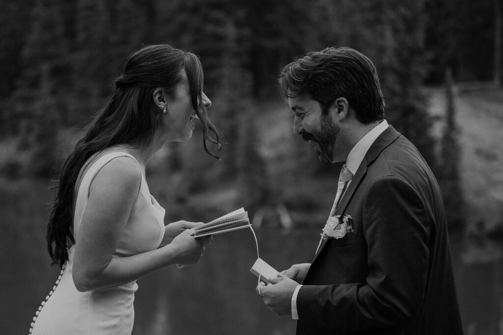 Bride and groom read vows near a Colorado alpine lake