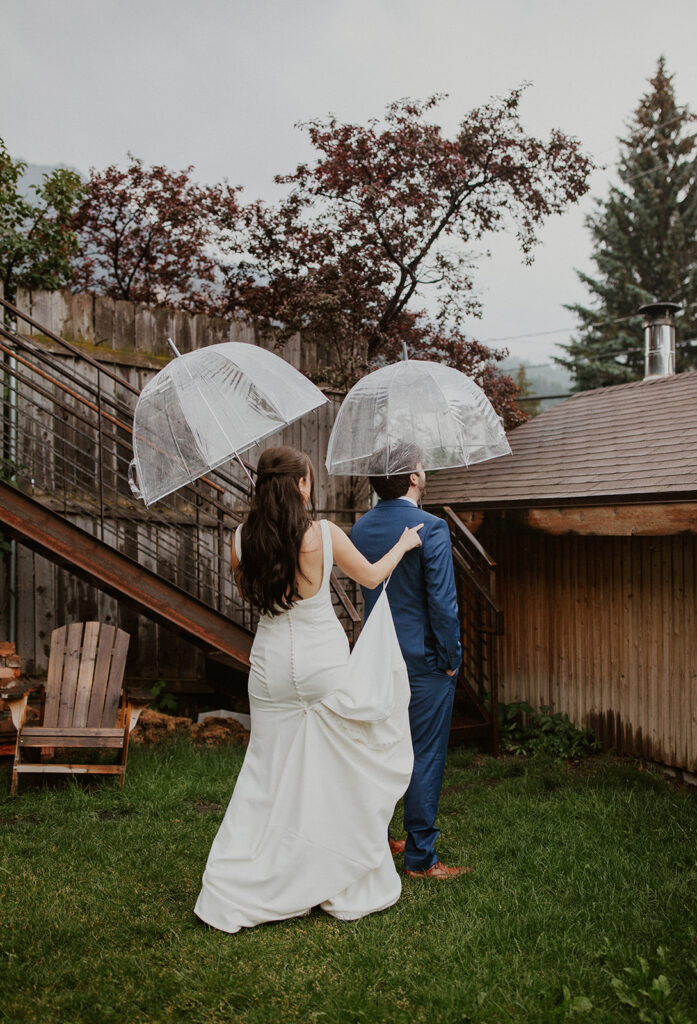 Bride and groom first look in the rain with clear umbrellas