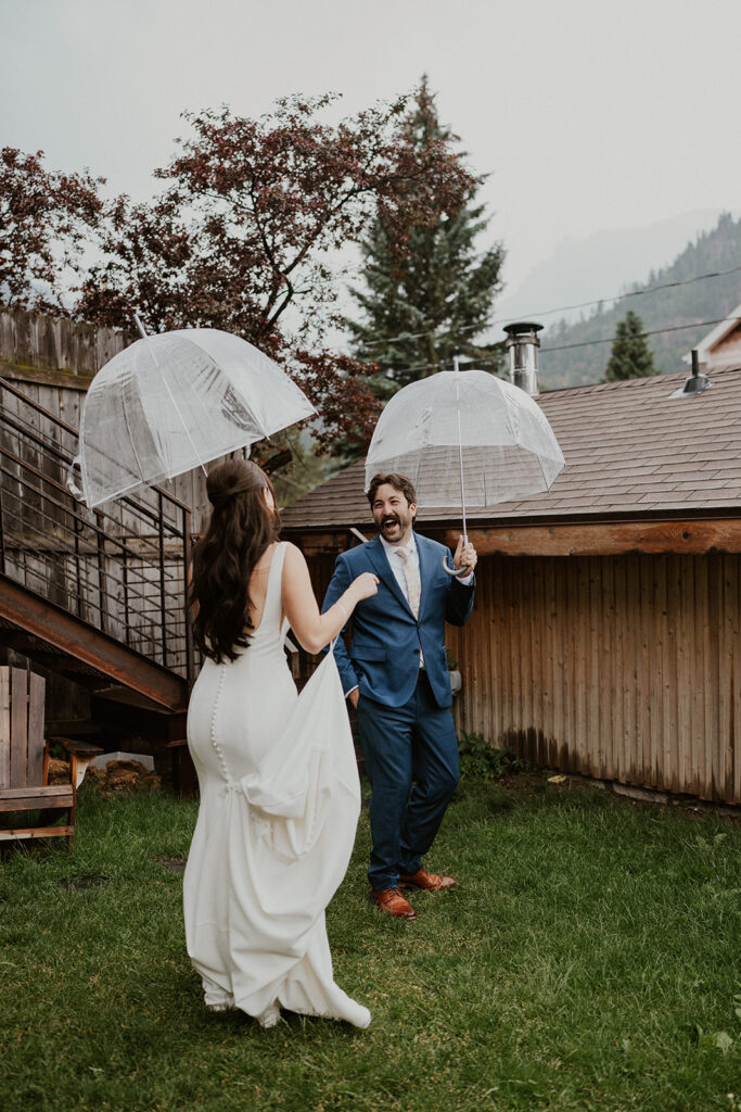 Bride and groom first look in the rain with clear umbrellas