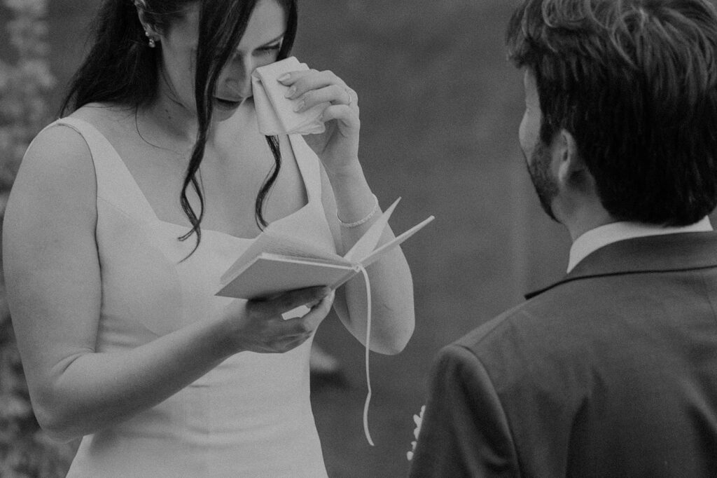Bride and groom read vows near a Colorado alpine lake
