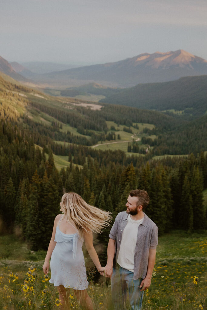 Couple holding hands and admiring the mountains in Crested Butte