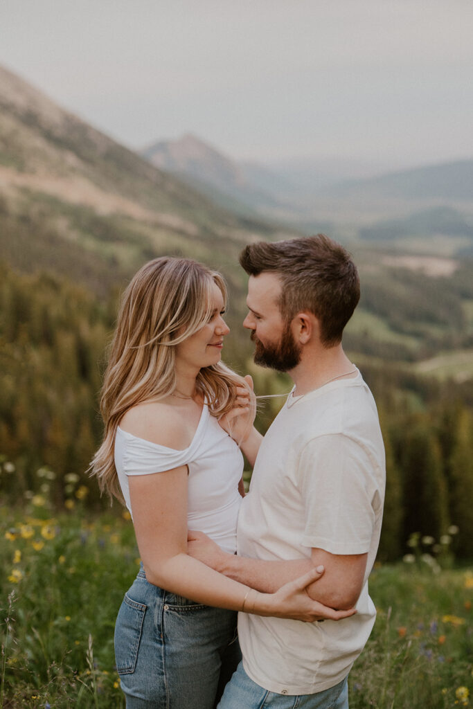 Close up shot of a couple holding onto each other in the mountains