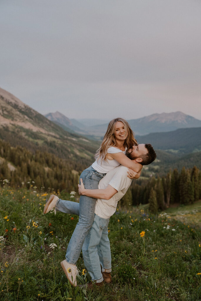 Man picking up his fiancé during their golden hour engagement shoot