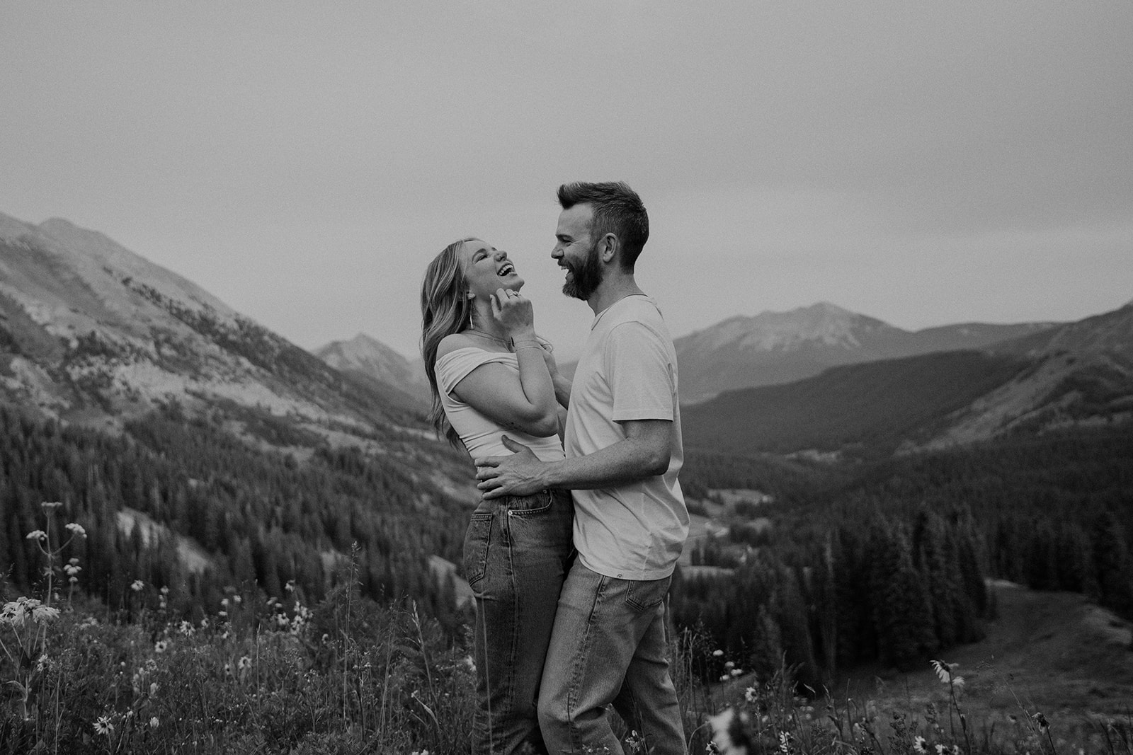 Black and white candid photo of a couple laughing during their Crested Butte engagement session