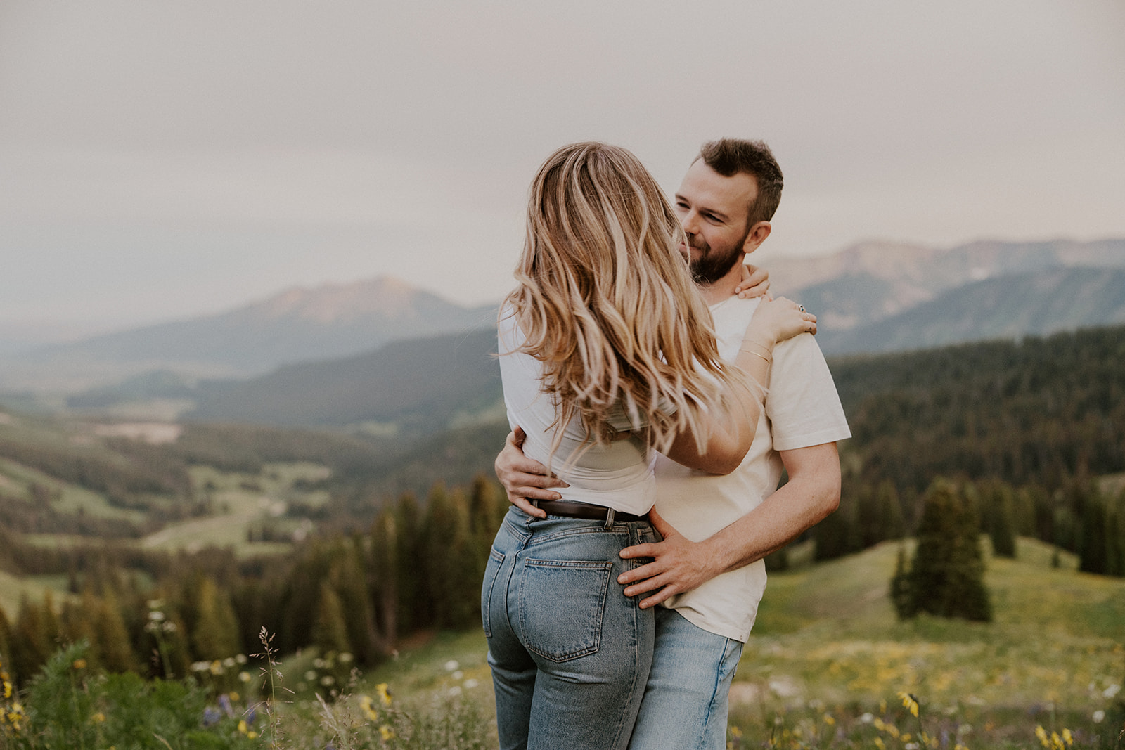 Man swinging his fiancé around during their Crested Butte engagement photoshoot 