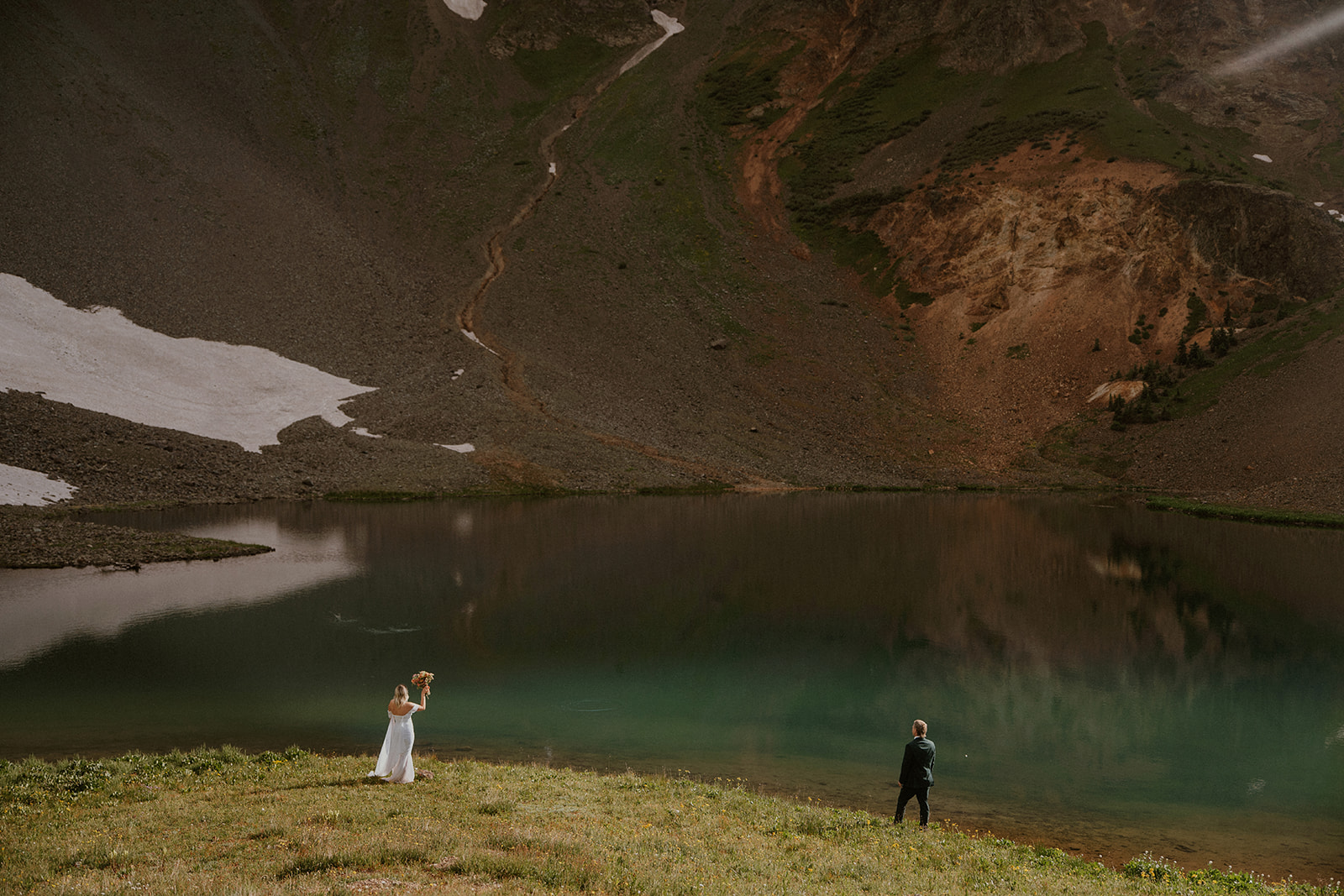 Bride and groom in front of a lake during their San Juan Mountains elopement in Coloado