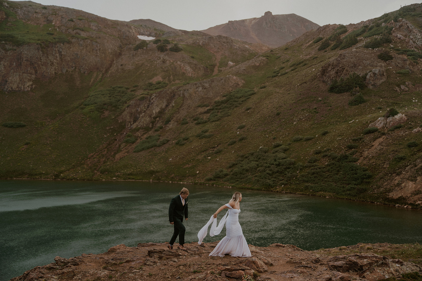 Bride and groom walking along the cliffs in the San Juan mountains