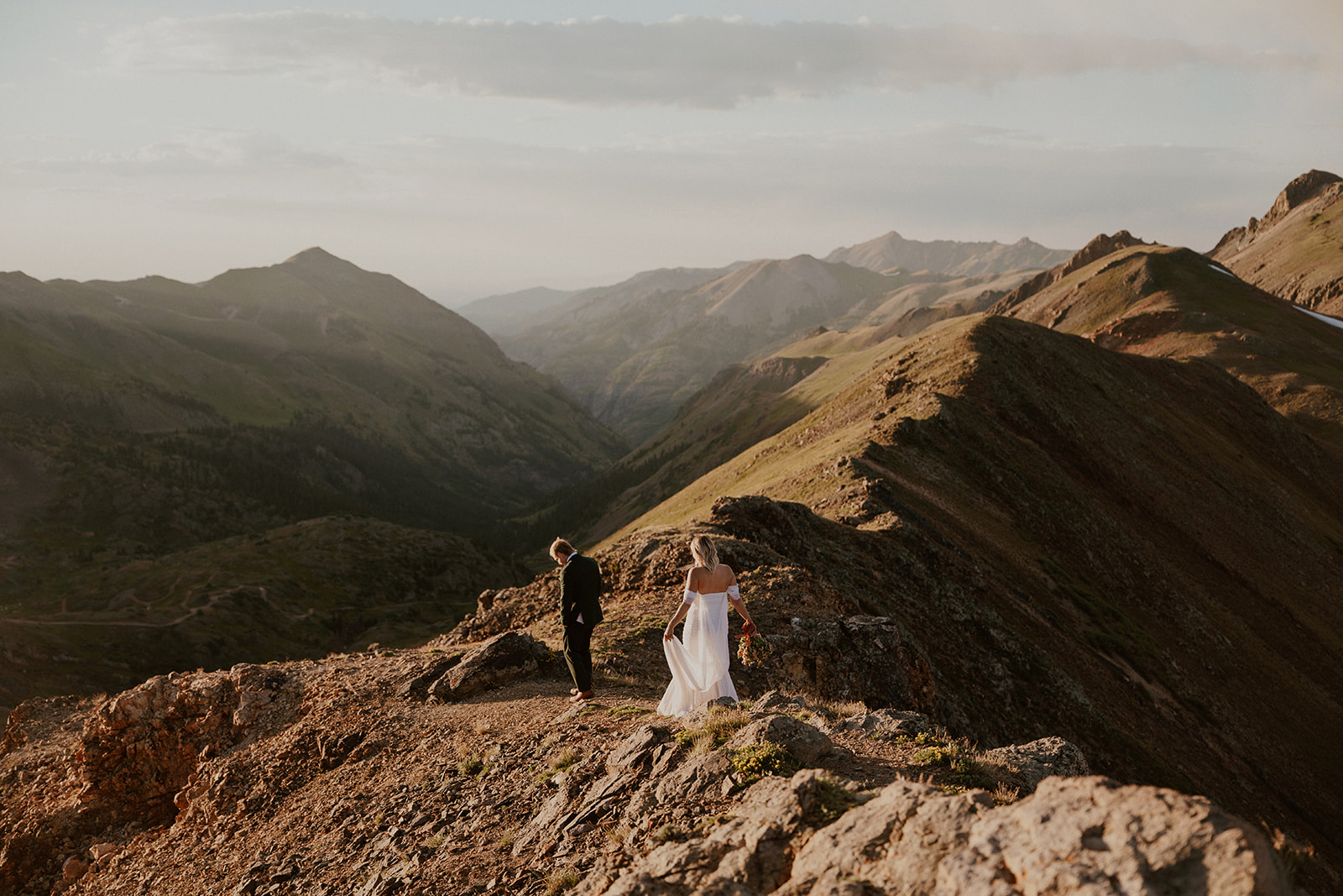 Bride and groom walking along California Pass in the San Juan mountains