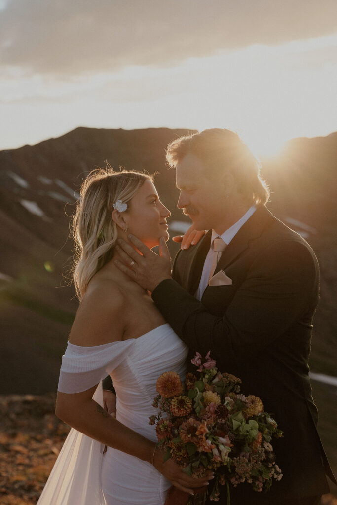 Groom caressing his brides face during golden hour in the San Juan mountains