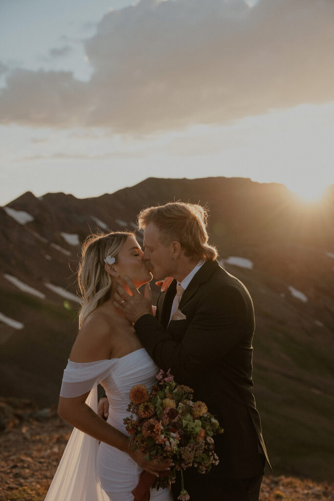 Bride and groom kissing during golden hour in the San Juan mountains