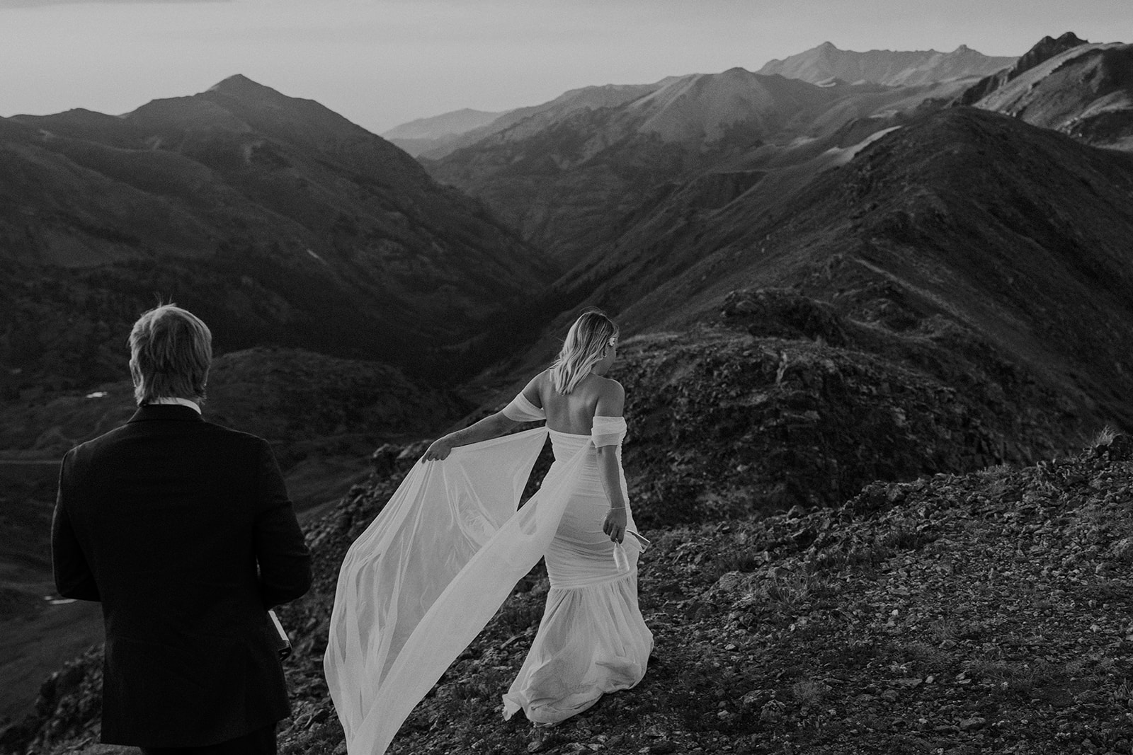 Black and white phot of a bride and groom walking in the San Juan mountains of Colorado