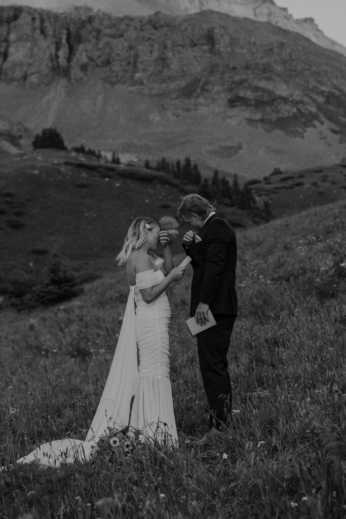 Black and white photo of a bride and groom getting emotional during their vows