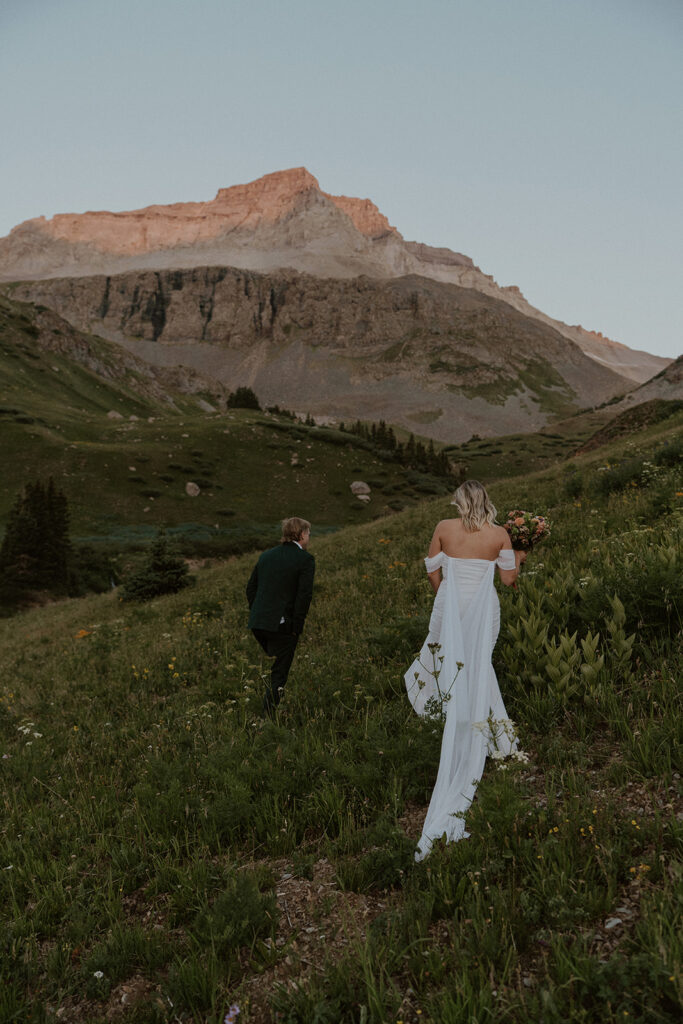 Bride and groom walking through the mountains