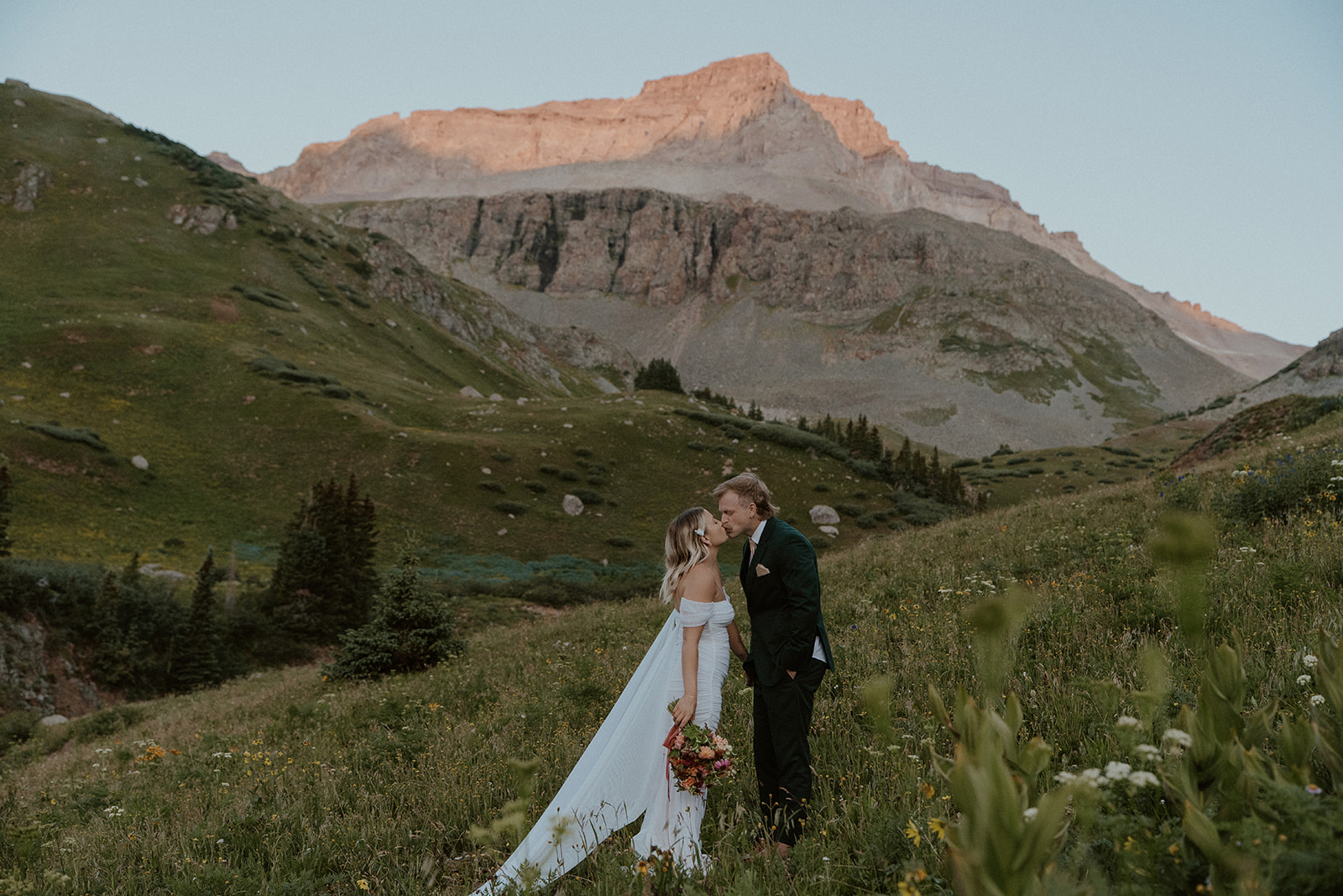 Bride and groom kissing in the mountains