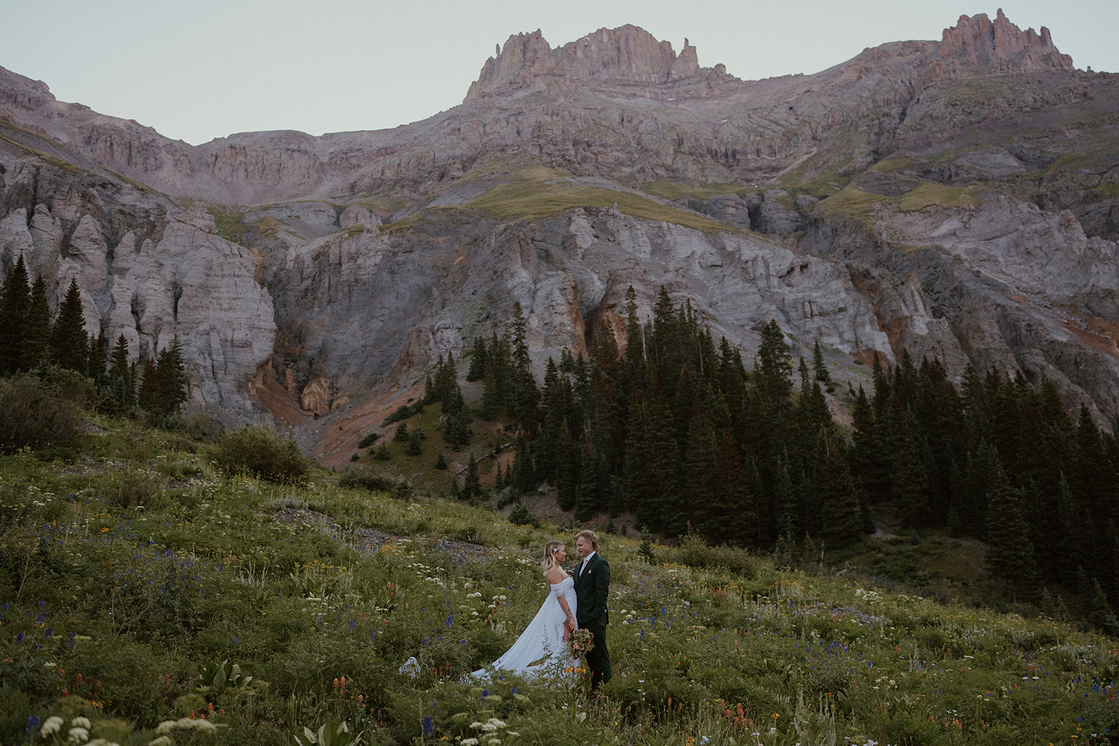 Bride and groom posing in the wildflowers for their San Juan mountains elopement photos in Colorado