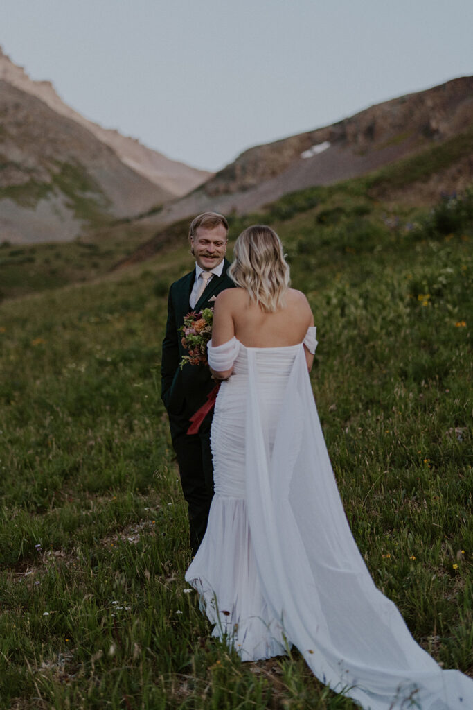 Groom smiling at his bride during their first look in the San Juan mountains
