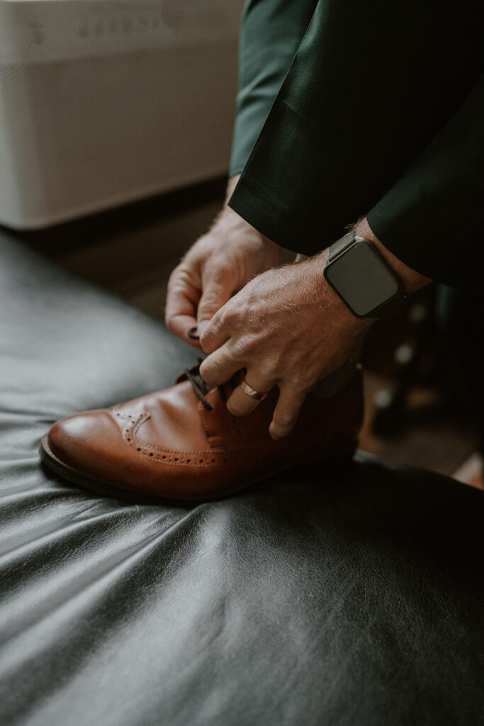Groom tying his shoes