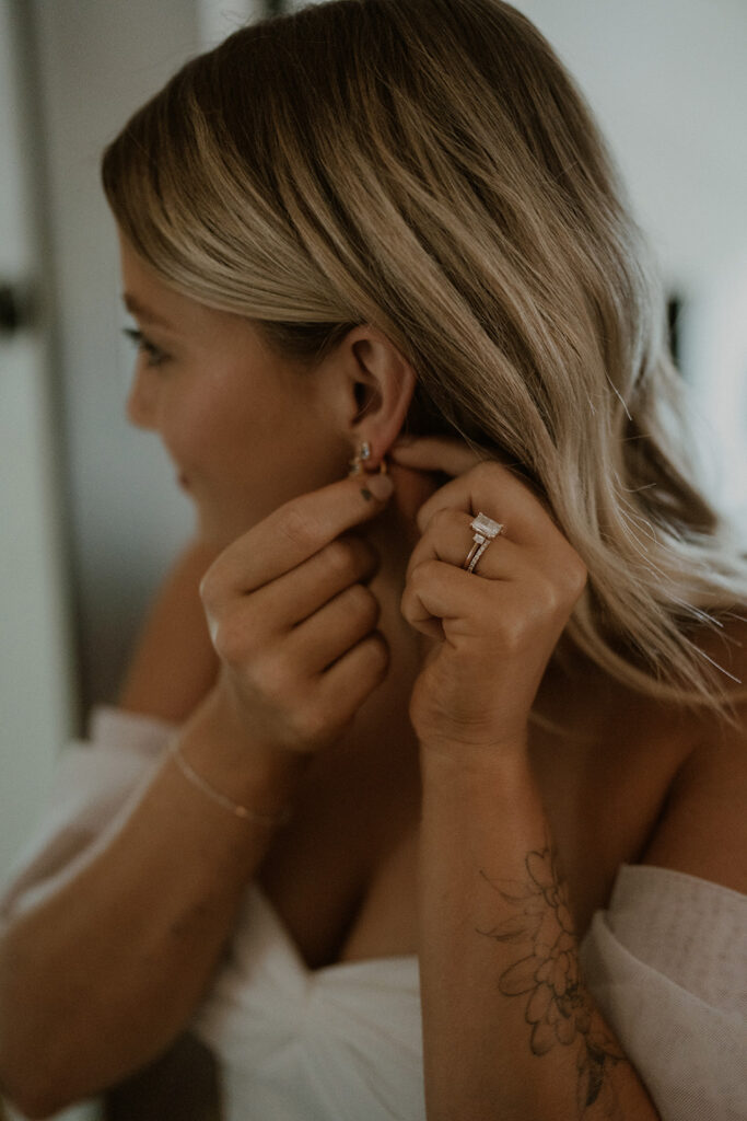 Bride putting her earrings in