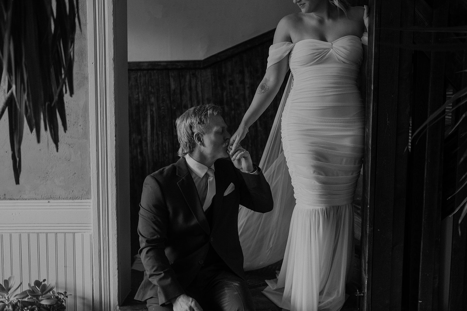 Black and white close up shot of a groom kissing his brides hand