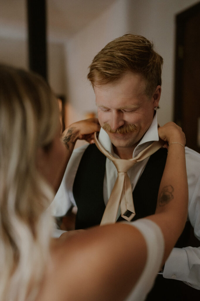 Bride and groom getting ready together at Western Hotel in Ouray