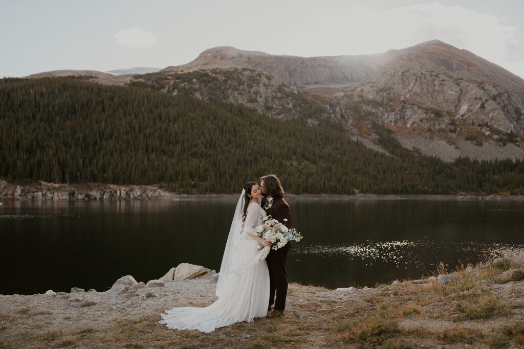 Lakeside bride and groom photo with mountains in the backdrop