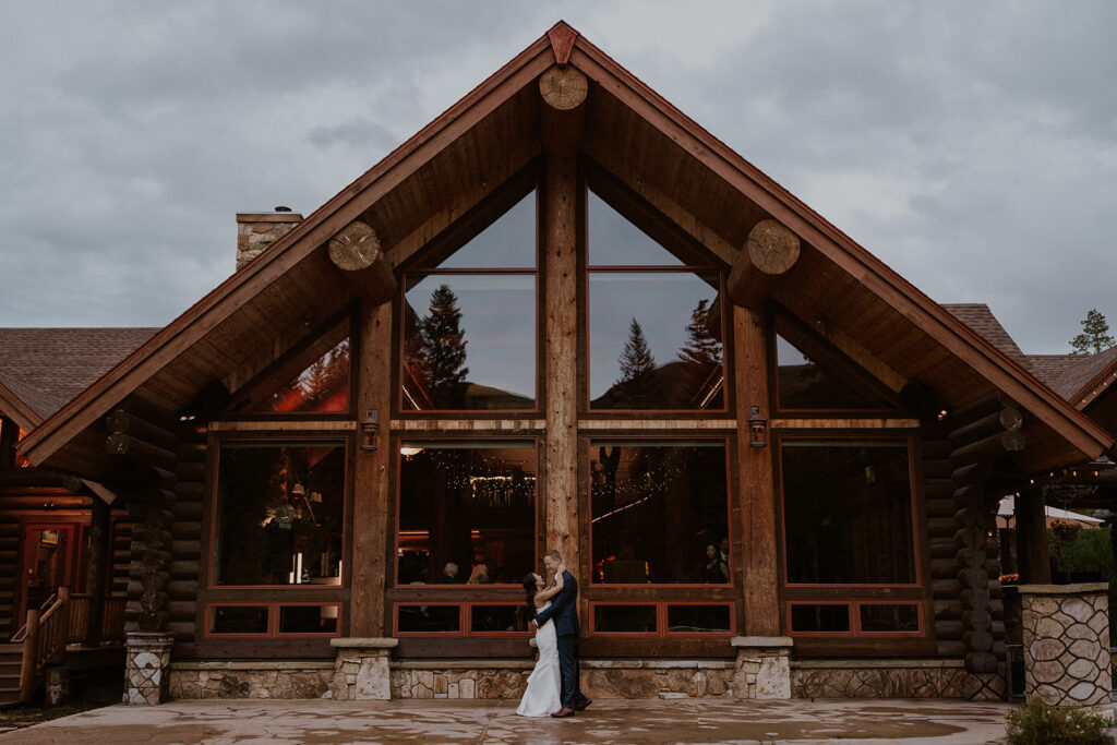 Bride and groom photos in front of the lodge at Breckenridge Nordic Center 