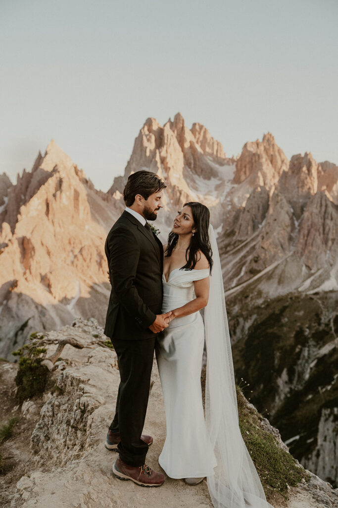 Couple stands with Tre Cime di Lavaredo in the backdrop