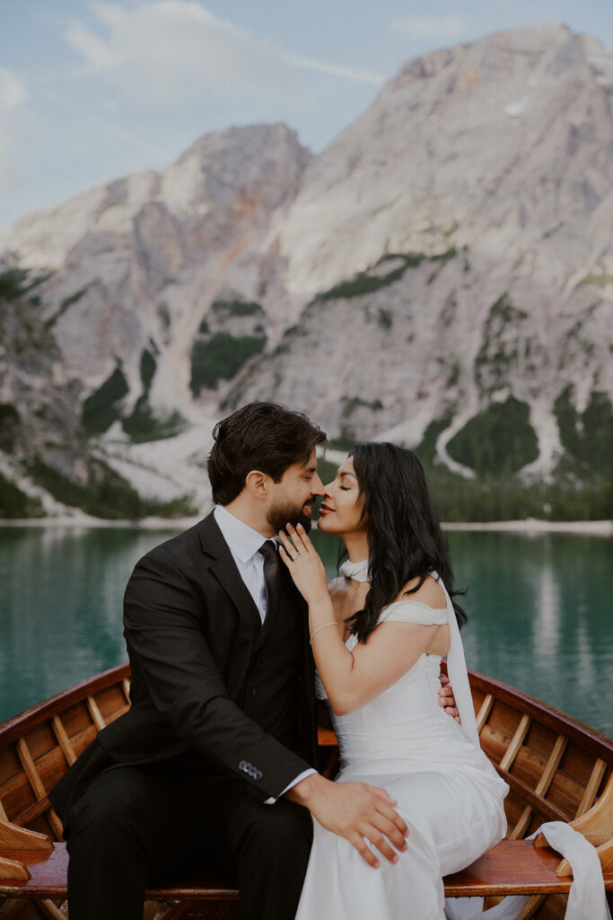 Couple sits on a canoe on Lago di Braies for their Dolomites elopement