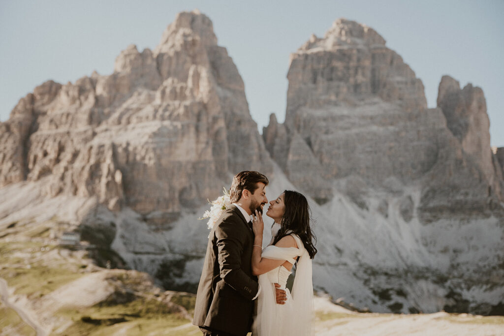 Couple stands with Tre Cime di Lavaredo in the backdrop