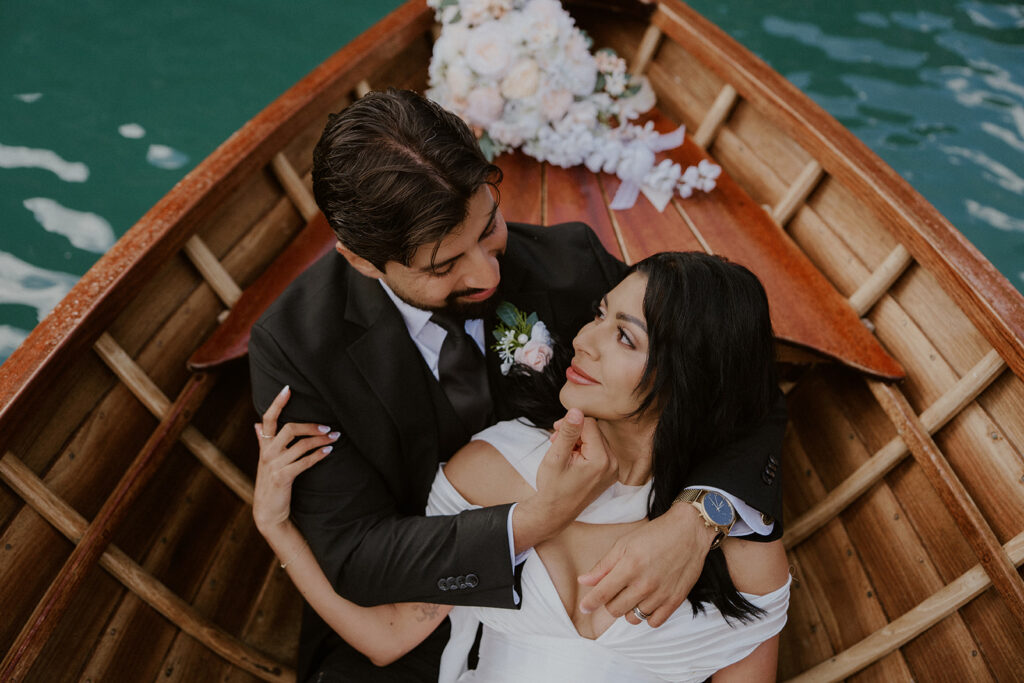 Couple sits on a canoe on Lago di Braies for their Dolomites elopement