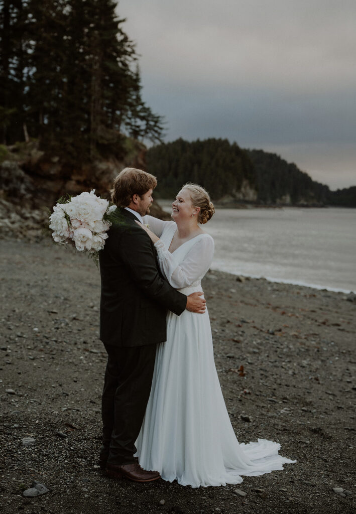Alaska elopement photos by the ocean with a mountain backdrop