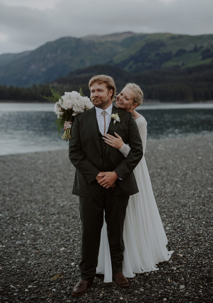 Alaska elopement photos by the ocean with a mountain backdrop