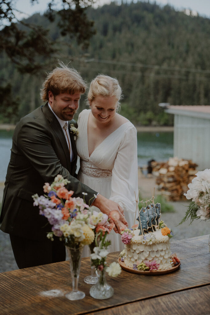 Bride and groom cut their elopement cake in Alaska