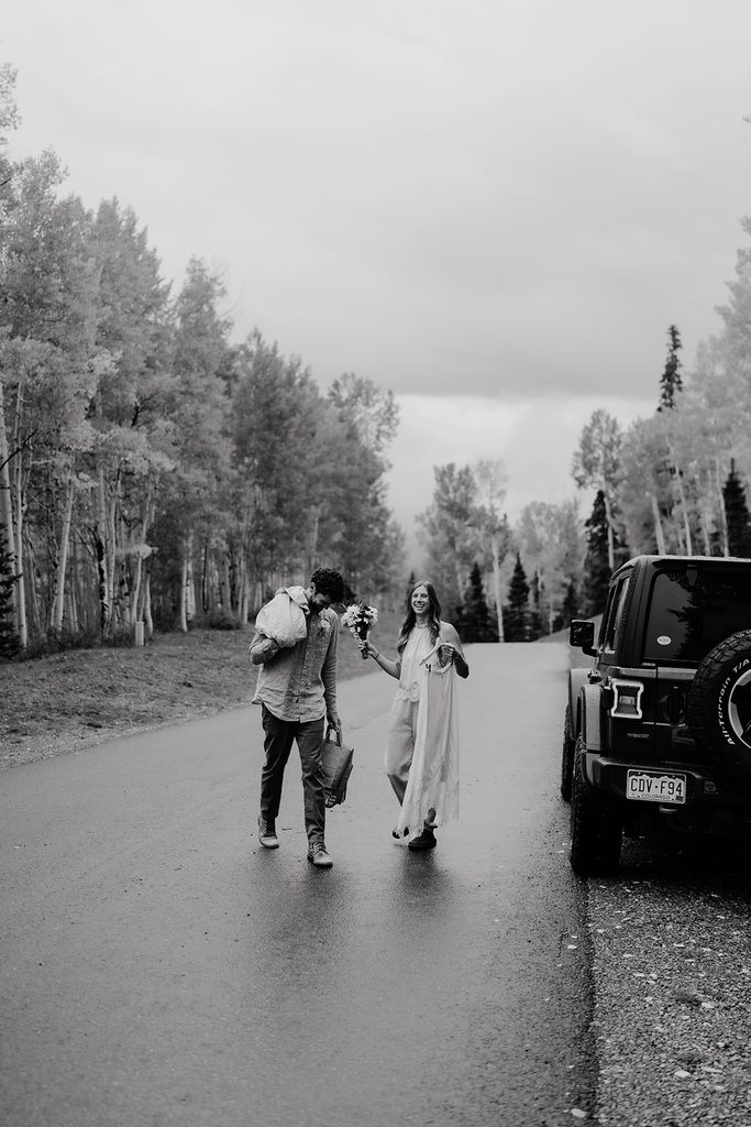 Bride and groom walk down a rainy street in Telluride, Colorado to their private wedding ceremony space